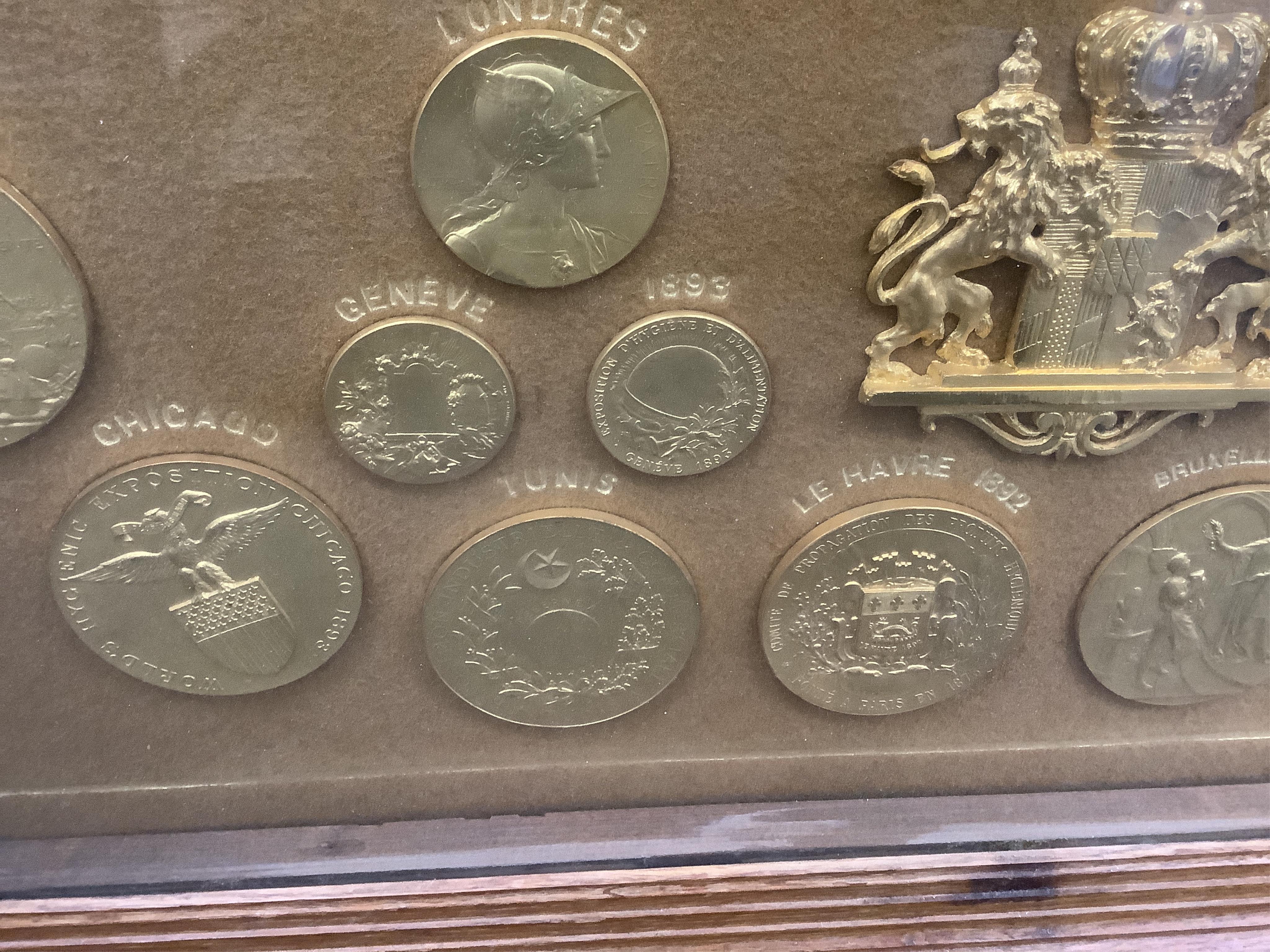 Smoking interest, a large oak framed display of gilt and enamel metal medals to Ed. Laurens, early 20th century, Containing gilt bronze prize medals, ranging from 1890-1906, various gilt and enamel medals with ribbons an